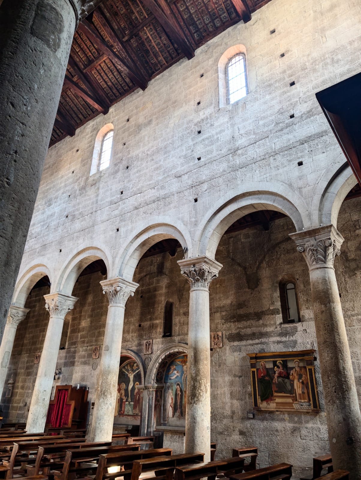 Scorcio della navata interna, scandita da colonne monolitiche con capitelli classicheggianti, archi a tutto sesto, le nicchie affrescate e il soffitto ligneo a capriate