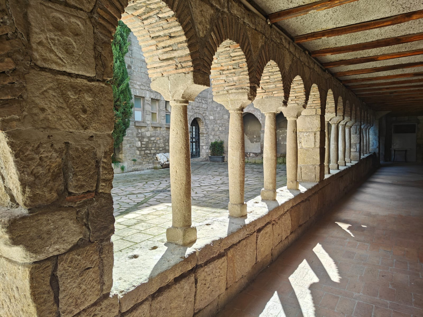 Scorcio del portico con le tipiche colonnine a fusto rigonfio e i capitelli a stampella del chiostro romanico (erroneamente detto "longobardo")